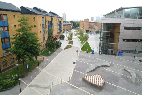 a park with a bench in the middle of a city at Stay QM in London