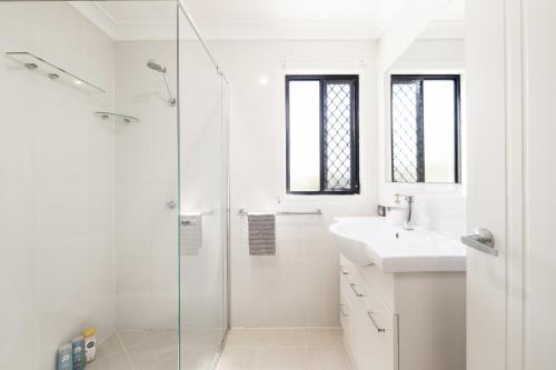 baño blanco con ducha y lavamanos en Studio, Popcorn, Close to transport & Restaurants! en Brisbane