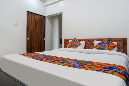 a bedroom with a large white bed with colorful sheets at Collection O Hotel Bliss Executive in Pune