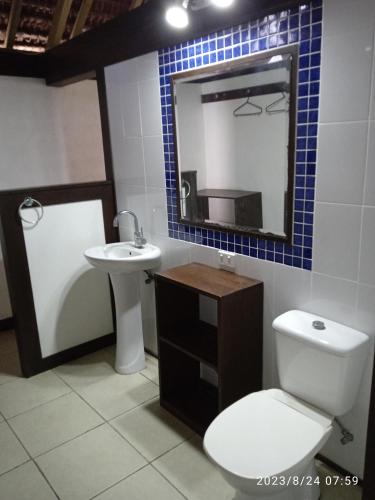 a bathroom with a toilet and a sink and a mirror at Serenity Bungalows in Port-Olry