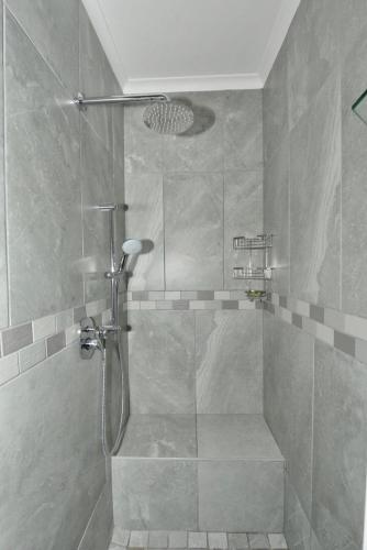 a shower with a glass door in a bathroom at Strandkiewiet in Jacobs Bay