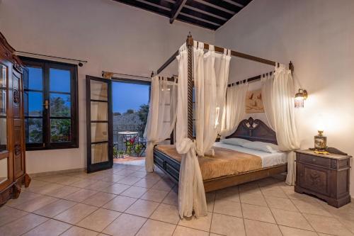 ein Schlafzimmer mit einem Himmelbett und einem Fenster in der Unterkunft Saint Michel Boutique Hotel in Rhodos (Stadt)