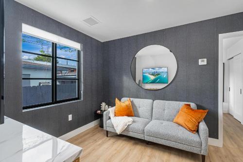 a living room with a couch and a mirror at Lux Retreat By Renzzi in Miami