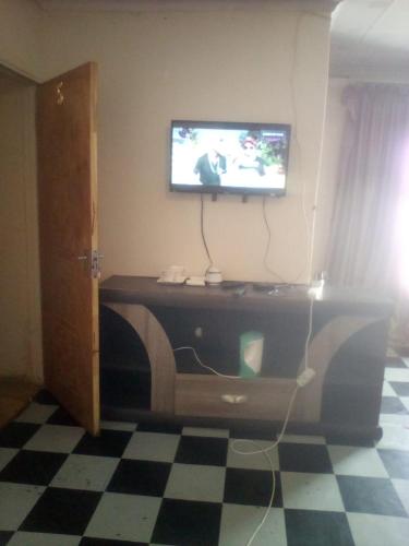 sala de estar con TV en la parte superior de un tocador en nafi guest house, en Phuthaditjhaba