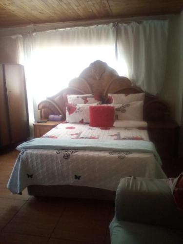 una cama con almohadas en una habitación en nafi guest house, en Phuthaditjhaba
