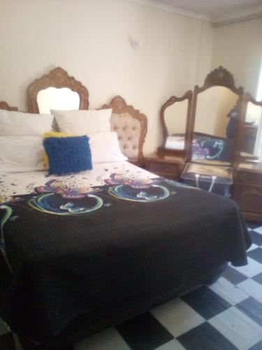 a bedroom with a large bed with a black blanket at nafi guest house in Phuthaditjhaba