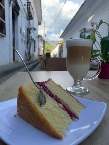 a piece of cake on a plate next to a cup of coffee at Casa hotel Dulce Candelaria in Santa Fe de Antioquia