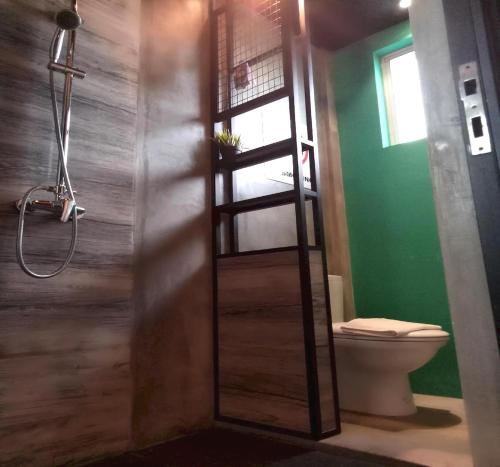 ein Bad mit einer Dusche und einem WC. in der Unterkunft OYO 90899 Tube Hotel Melaka in Kelebang Besar