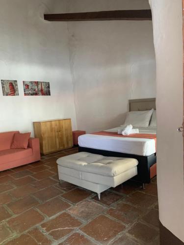 a room with two beds and a couch at Casa hotel Dulce Candelaria in Santa Fe de Antioquia