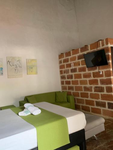 a room with two beds and a brick wall at Casa hotel Dulce Candelaria in Santa Fe de Antioquia