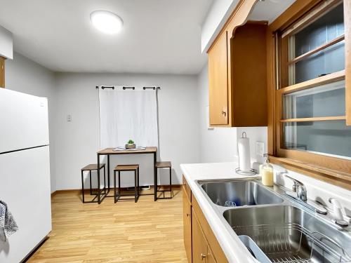 eine Küche mit einem Waschbecken und einem Tisch in der Unterkunft Family Friendly 3 Br 2 Bath Duplex Sleeps 9! in Des Moines