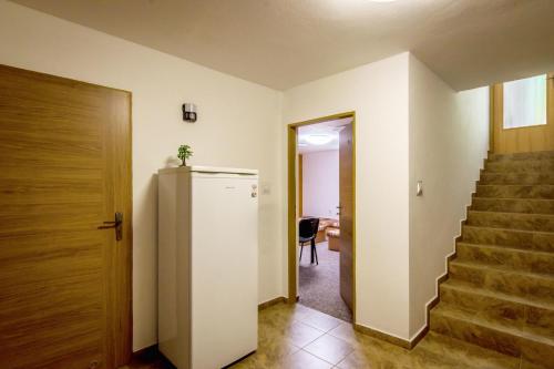 a hallway with a refrigerator and a staircase at Ubytovňa Pali in Kežmarok