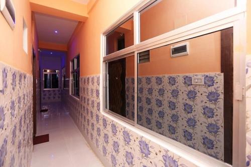 um corredor de uma casa de banho com azulejos azuis e brancos em Goroomgo Savashi Puri em Puri