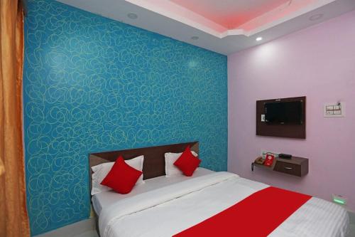 um quarto com uma cama com uma parede azul em Goroomgo Savashi Puri em Puri