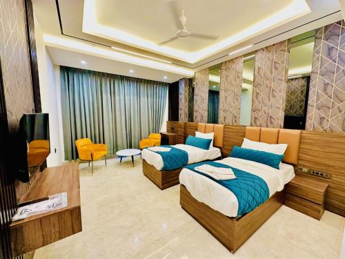 een hotelkamer met 2 bedden en een televisie bij The Armani Hotel At Delhi Airport in New Delhi
