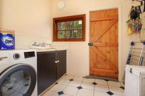a washing machine in a kitchen with a door at Allen Street in Beechworth