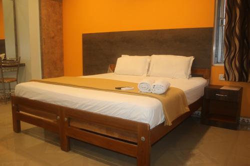 a bedroom with a bed with two towels on it at Hotel Sikara, Kumbakonam in Kumbakonam