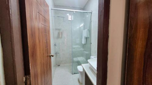 bagno con doccia in vetro e servizi igienici di Salig Hotel a Dharamshala