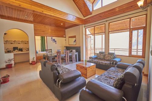 a living room with couches and a dining room at The Bliss Cottage Manali Luxury Apartment and villa in Manāli