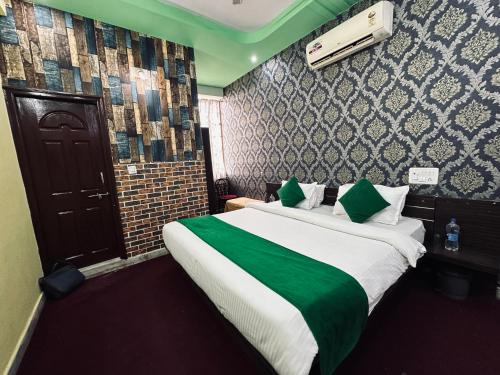 Habitación de hotel con cama grande con manta verde en Hotel Umaid Villa, en Udaipur