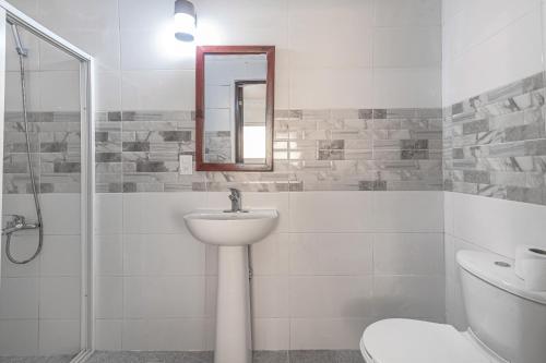 a bathroom with a sink and a toilet and a mirror at Los Corales Del Sur, Santo Domingo Este nearby Airport, Beach, Pool Water Park in La Viva