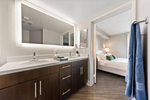 a bathroom with a sink and a large mirror at Blue Topaz Retreat - Spacious 3BR Gorgeous City views in Los Angeles
