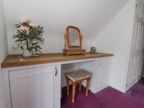 a dressing table with a mirror and a stool at The Hideaway Beach House in New Romney