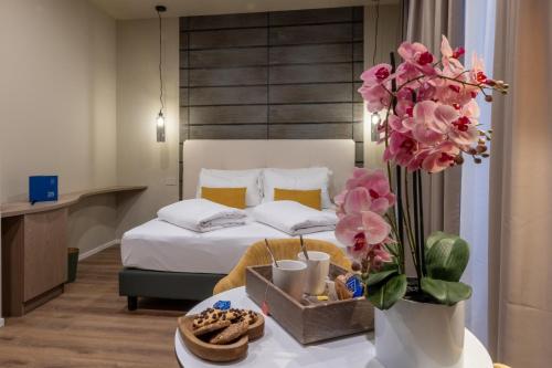a hotel room with a bed and a table with flowers at Soul of Trento San Martino in Trento