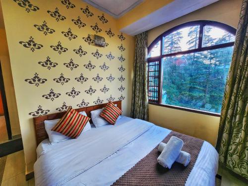 a bedroom with a large bed and a window at Hotel Taj Palace near Mall Road in Shimla