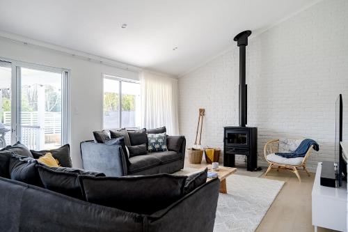 a living room with a couch and a fireplace at beached at mollymook in Mollymook