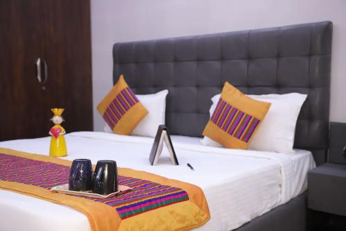 a bedroom with a large bed with yellow and purple pillows at divine India Service Apartment 1Bhk,L-36B,Saket in New Delhi