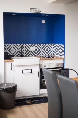 - une cuisine avec une cuisinière et un mur bleu dans l'établissement El NIDO proche d'Etretat et Fécamp, à Vattetot-sur-Mer