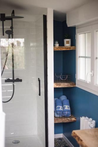 La salle de bains est pourvue d'une douche et de murs bleus. dans l'établissement El NIDO proche d'Etretat et Fécamp, à Vattetot-sur-Mer
