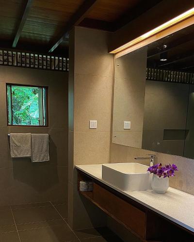 a bathroom with a sink and a mirror at Maison Samara in Hikkaduwa