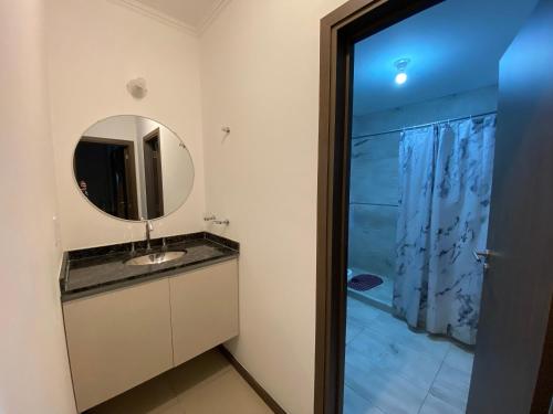 a bathroom with a sink and a mirror at Departamento con piscina en pleno centro in Villa Carlos Paz