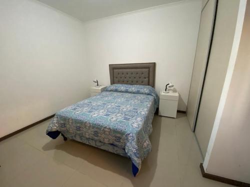 a small bedroom with a bed and two night stands at Departamento con piscina en pleno centro in Villa Carlos Paz