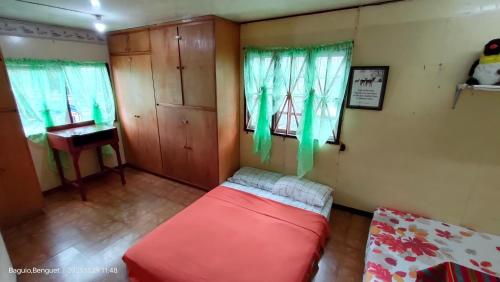 a living room with a red couch and a piano at Kochimoto Homestay in Baguio