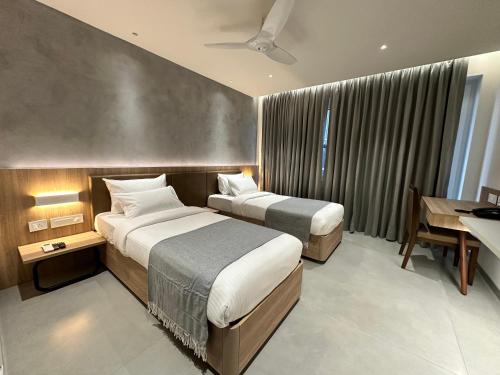 a hotel room with two beds and a desk at 32 Urban by Akoya Hotels in Hyderabad