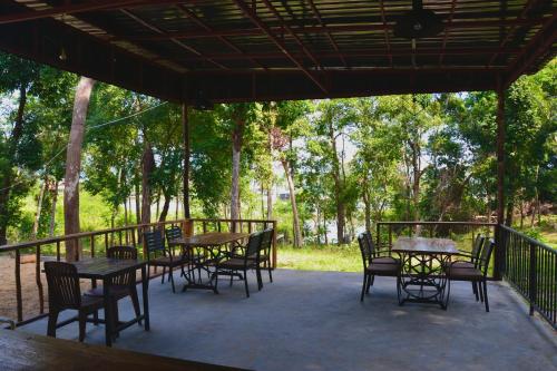 an outdoor patio with tables and chairs and trees at Koh Rong Lagoon in Koh Rong