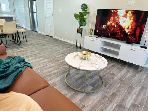 ein Wohnzimmer mit einem Sofa, einem TV und einem Tisch in der Unterkunft Modern apt-King bed-Free parking-Wi-fi in Brownsville