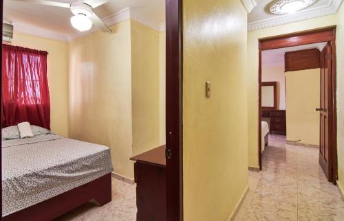 a bedroom with a bed and a door leading to a hallway at Los Corales Del Sur, Santo Domingo Este nearby Airport, Beach, Pool Water Park in La Viva