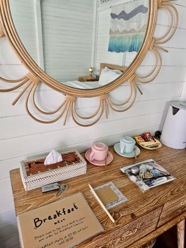 a wooden table with a mirror and a table with a table sidx sidx at Mambo Hill Resort in Nusa Penida