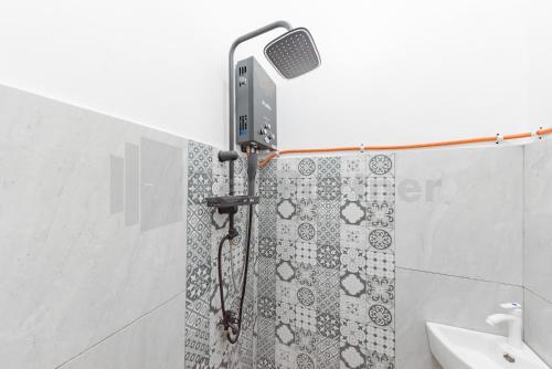 eine Dusche mit Duschkopf im Bad in der Unterkunft JM Guest House Lamaran RedPartner in Karawang