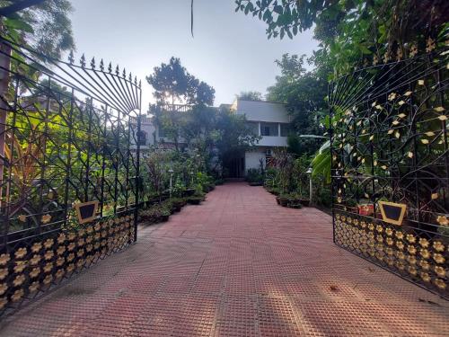 um passadiço de tijolos com um portão em frente a um edifício em Rajlaxmi Resort - Pure Veg em Bolpur