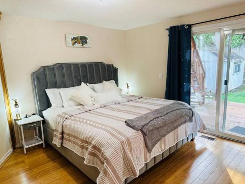 a bedroom with a large bed with a large window at Family Fun Retreat Home with a Heart in Tualatin