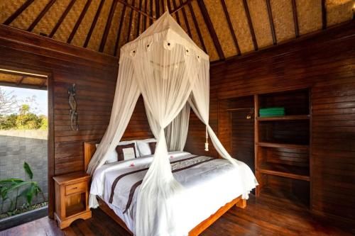 een slaapkamer met een bed met een klamboe bij Maharatu Villa Lembongan in Nusa Lembongan