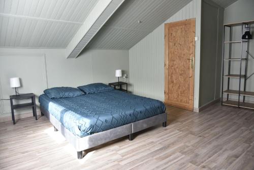 - une chambre avec un lit bleu et du parquet dans l'établissement Gîte sur Grand Fort Philippe, à Grand-Fort-Philippe