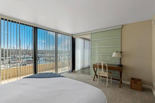 una camera con letto e scrivania con finestra di Harbor Front Haven With Stunning Marina View a Los Angeles