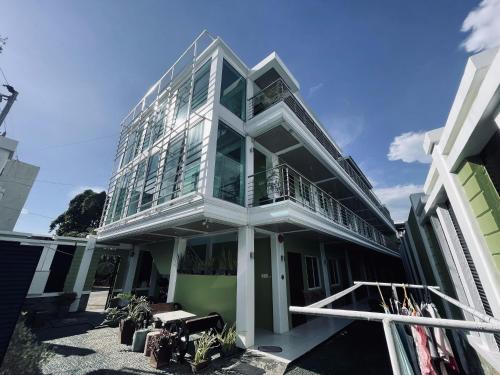 a large glass building with a balcony on it at Delta Star Manor in Naga