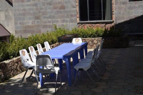 a blue table with white chairs around it at Villadzor Apart Hotel in Tsaghkadzor